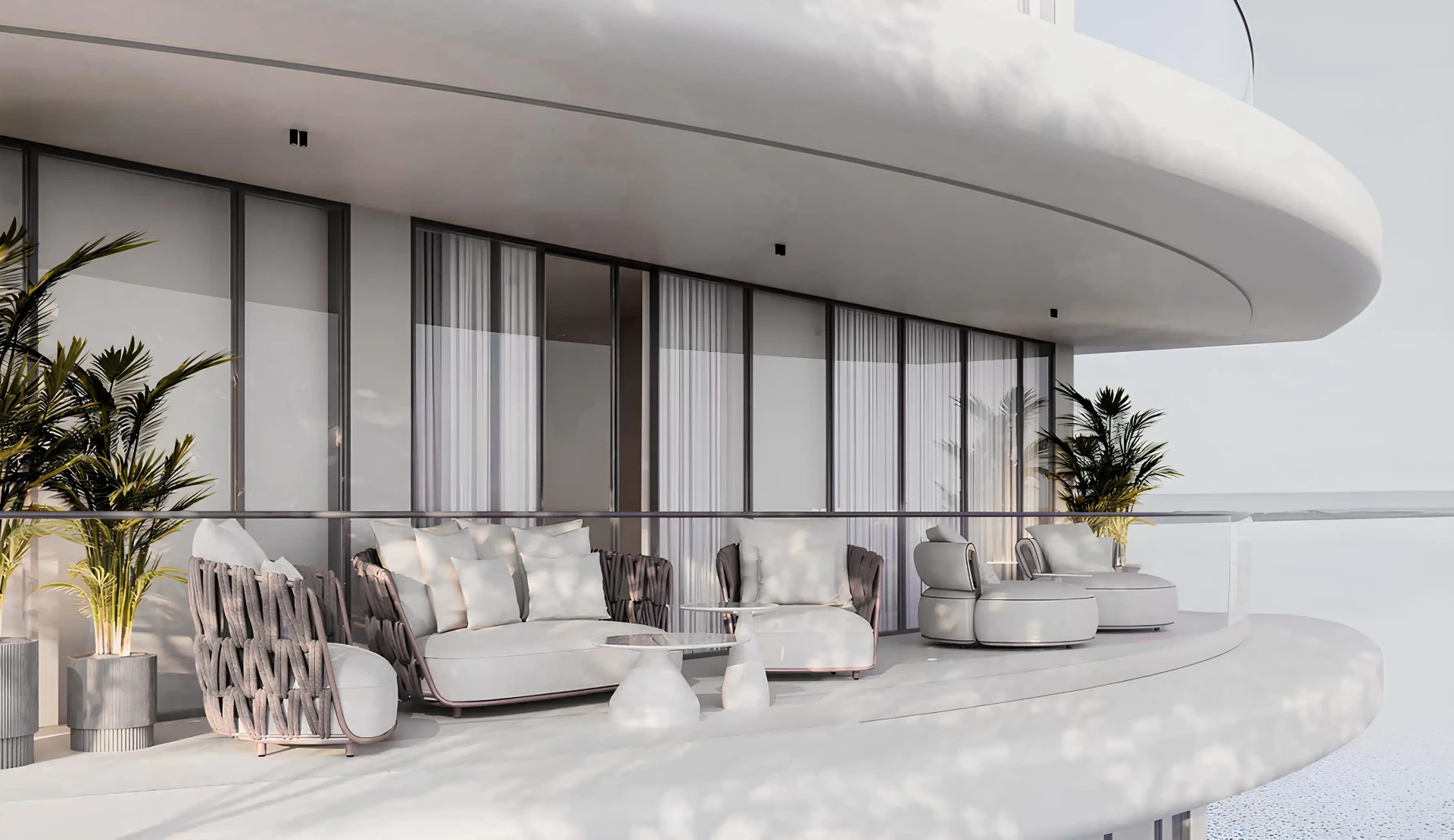 Zaoblená terasa apartmánu s designovým lounge nábytkem a výhledem na moře