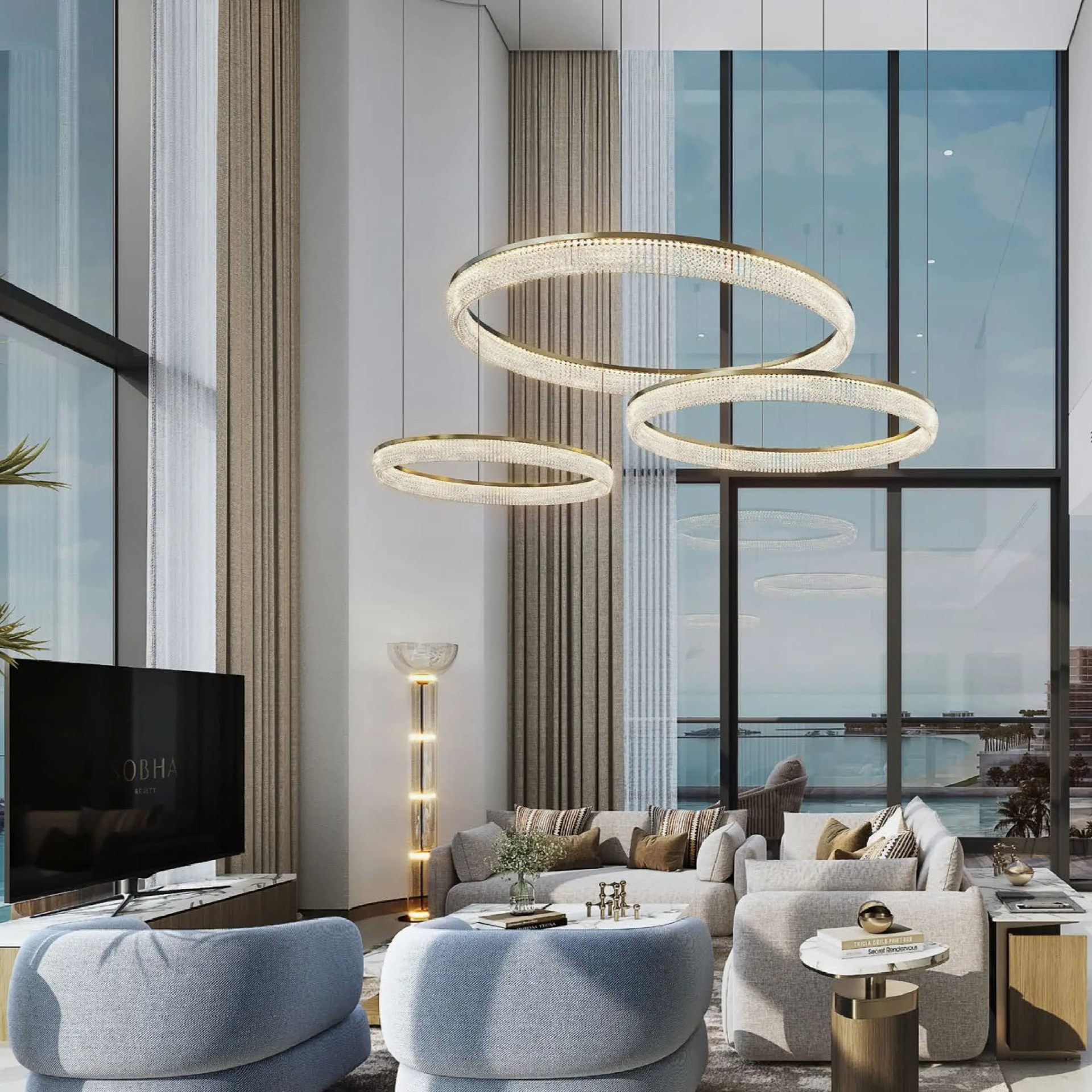 Double-height living room with circular chandelier and panoramic sea view in a Sobha Aquacrest apartment